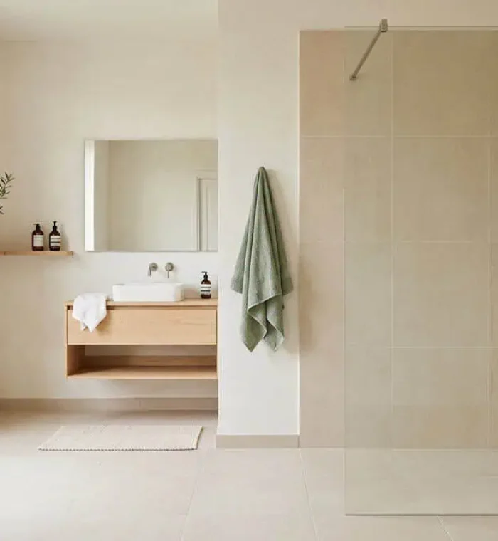 Douche à l’italienne de plain-pied avec paroi en verre dans une salle de bain moderne et lumineuse