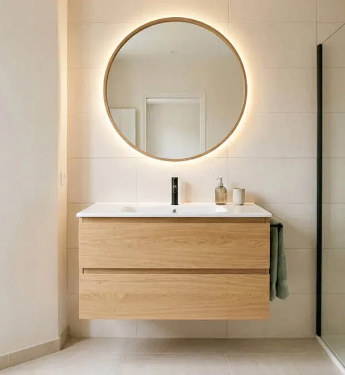 Meuble vasque suspendu en bois clair avec tiroirs dans une salle de bain moderne et lumineuse