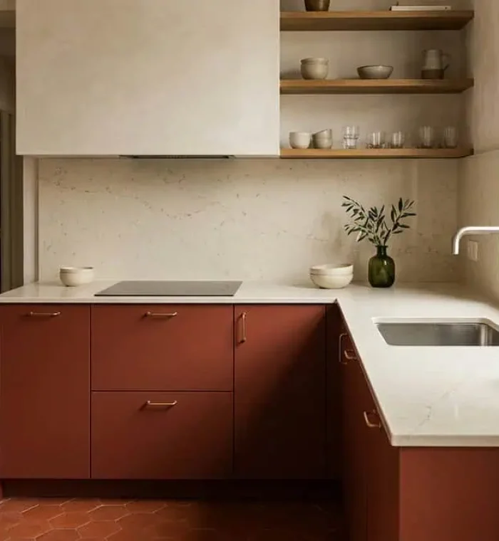 Plan de travail en quartz crème sur une cuisine contemporaine aux façades rouge brique mat